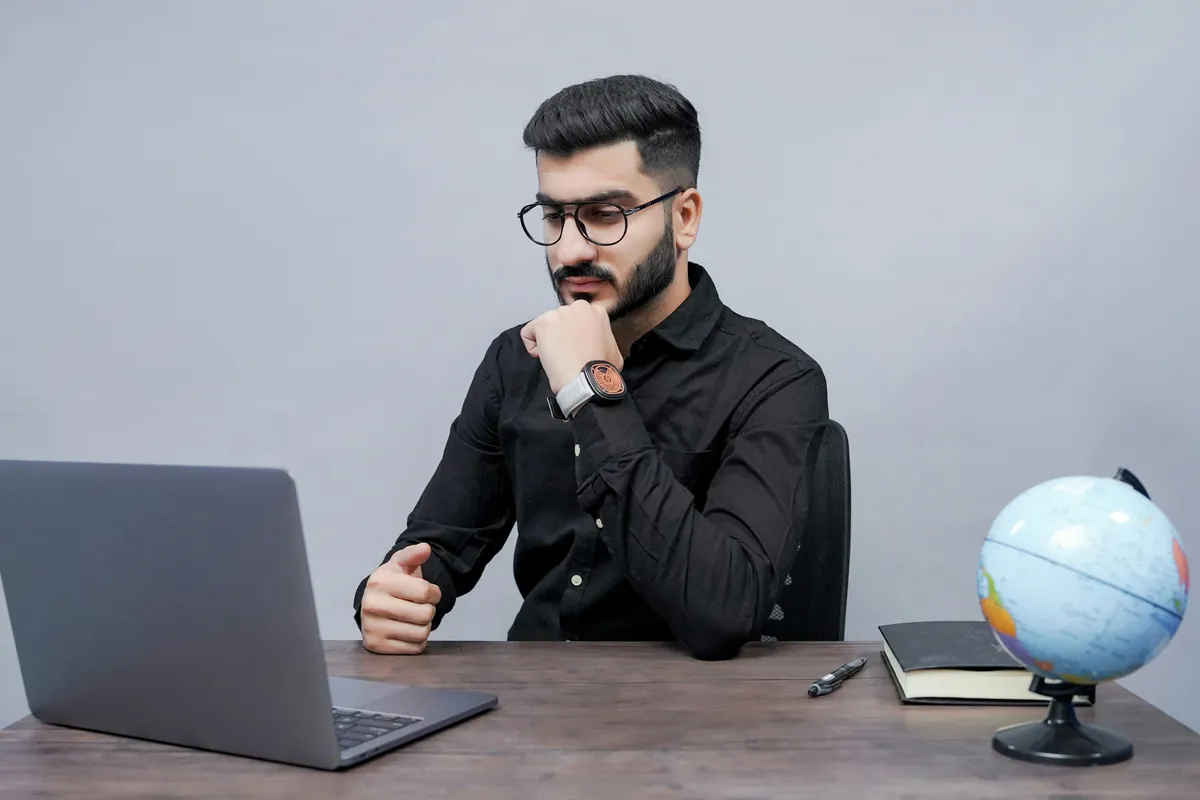 A business owner studying world markets on a laptop